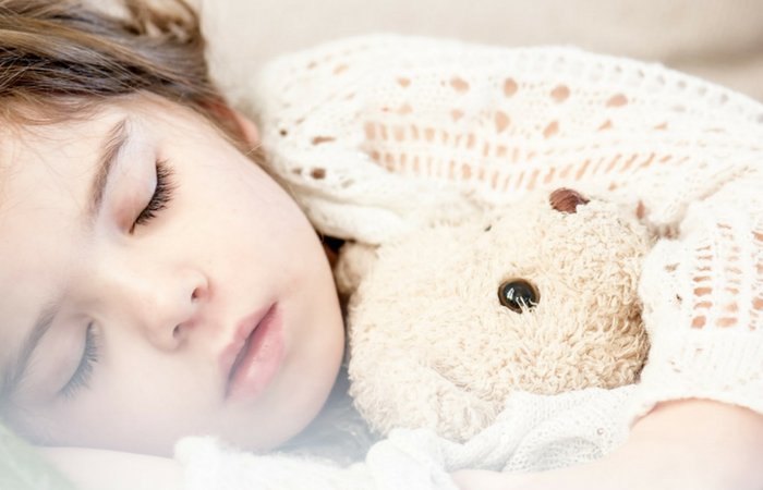 child asleep with teddy bear