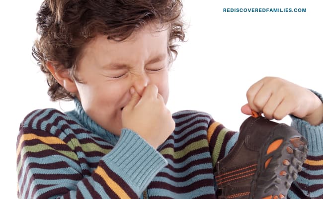 child with a shoe holding his nose