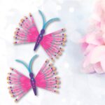two clothes pin butterflies next to spring flowers