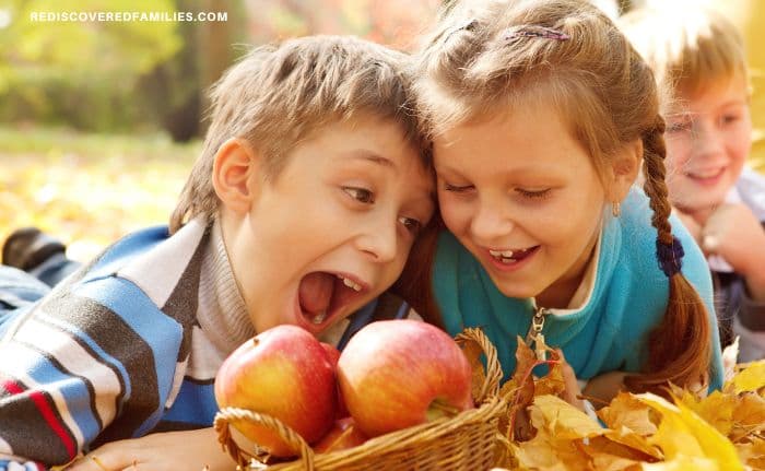 laughing children with a basket of apples