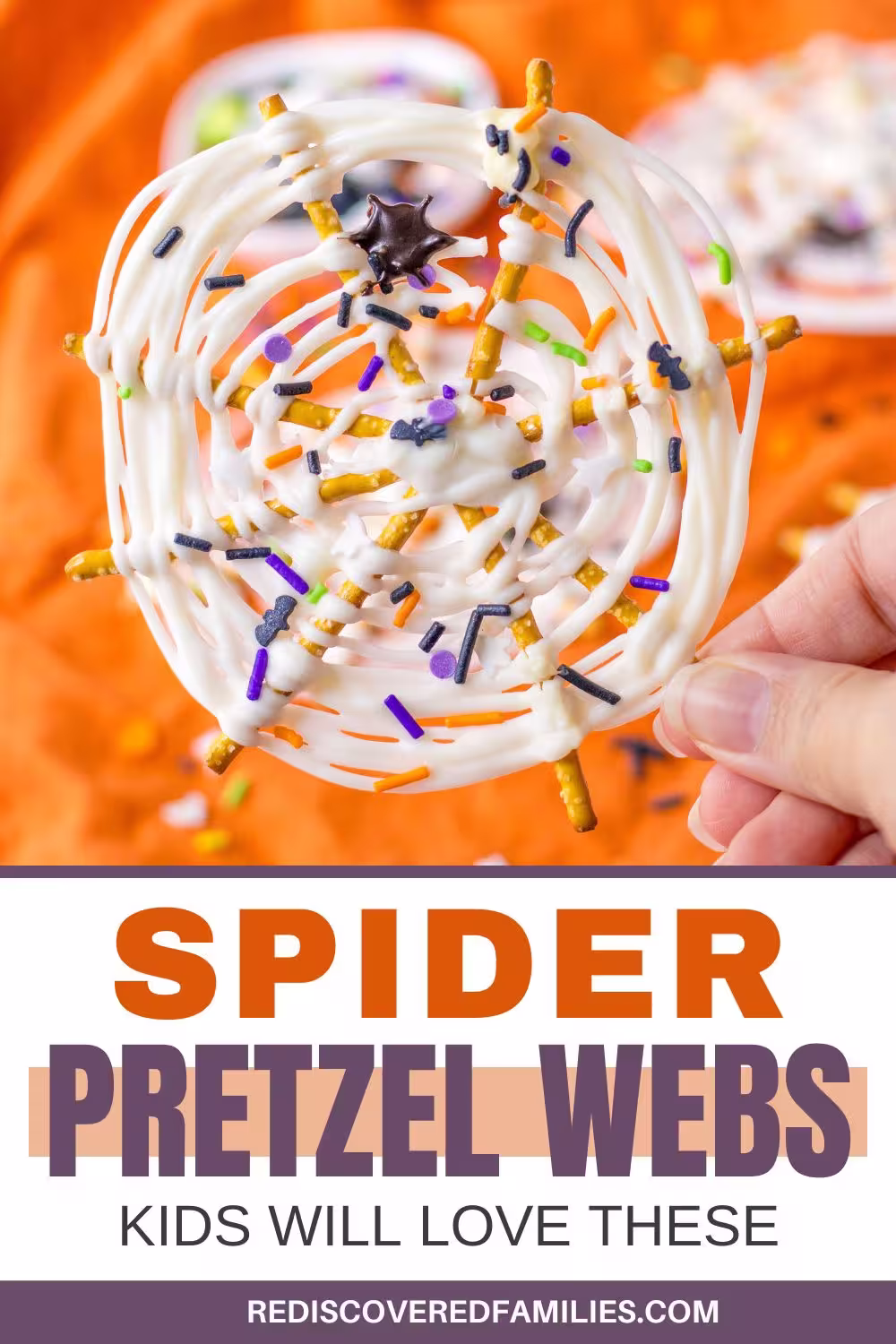 Hand-holding a white chocolate spider web treat made with pretzels and Halloween sprinkles. Text overlay reads: spider pretzel webs — kids will love these.