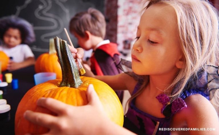 young child painting a pumpkin