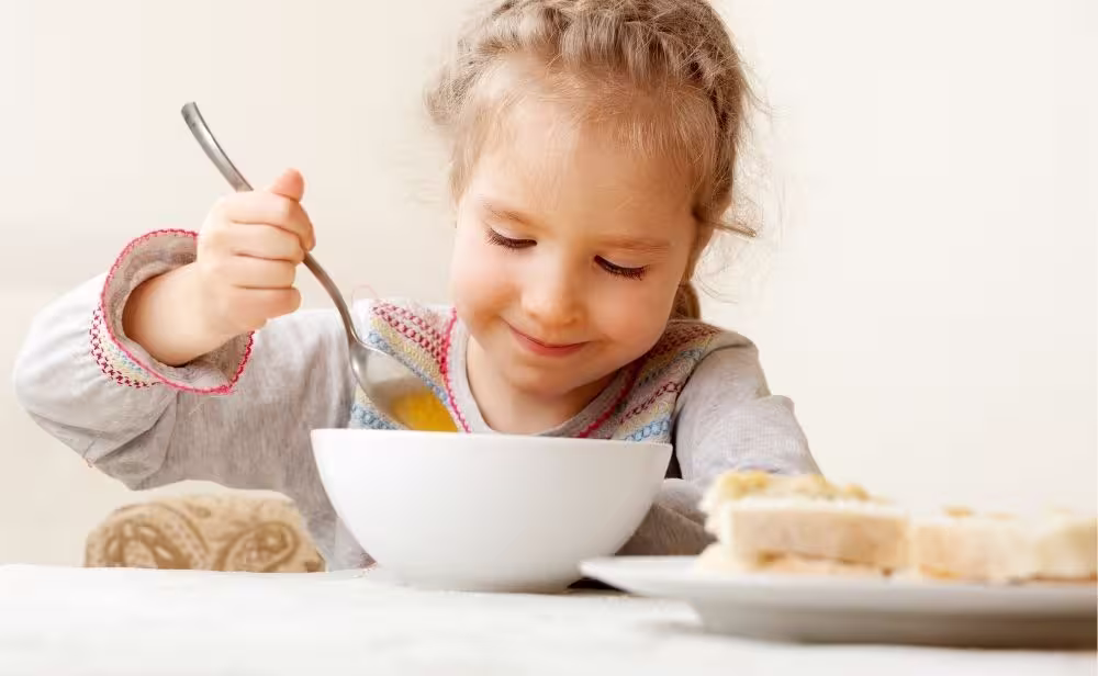 child eating soup