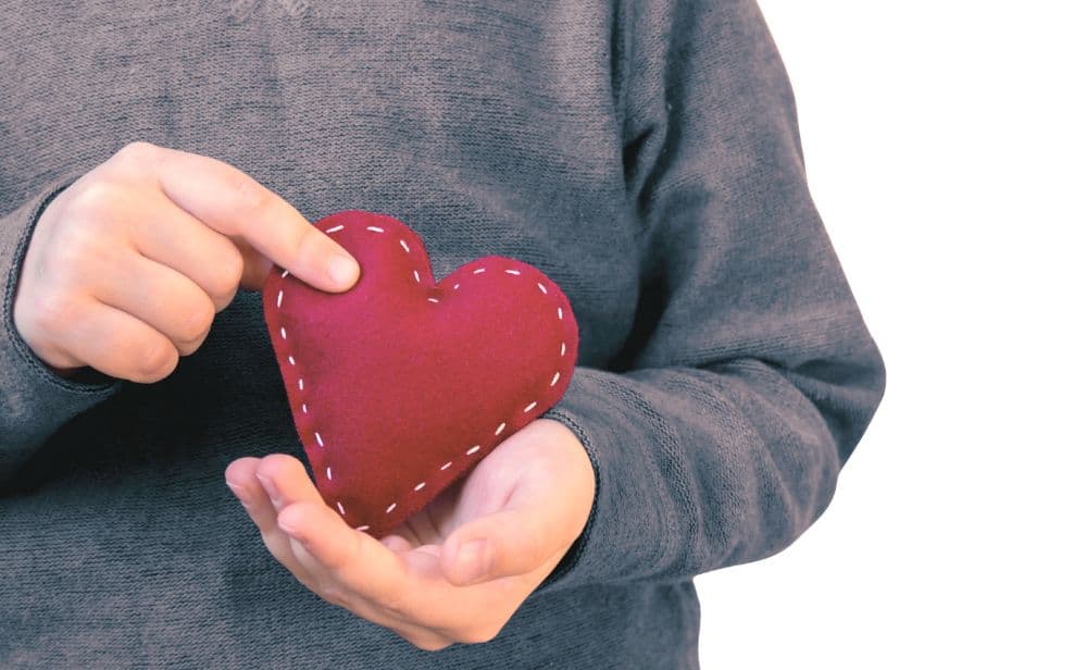 child's hands holding a felt heart