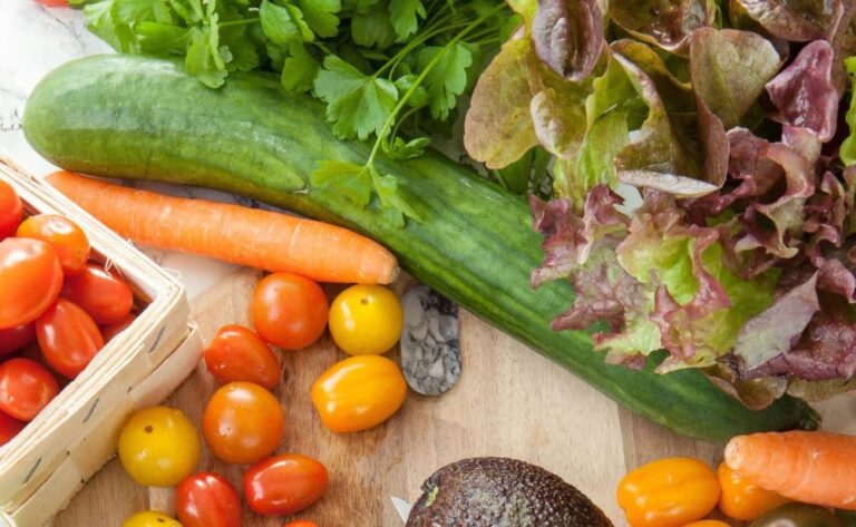 Cutting board with a variety of salad vegetables ready to made into a salad