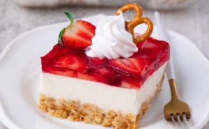 A square of strawberry pretzel salad on a white plate
