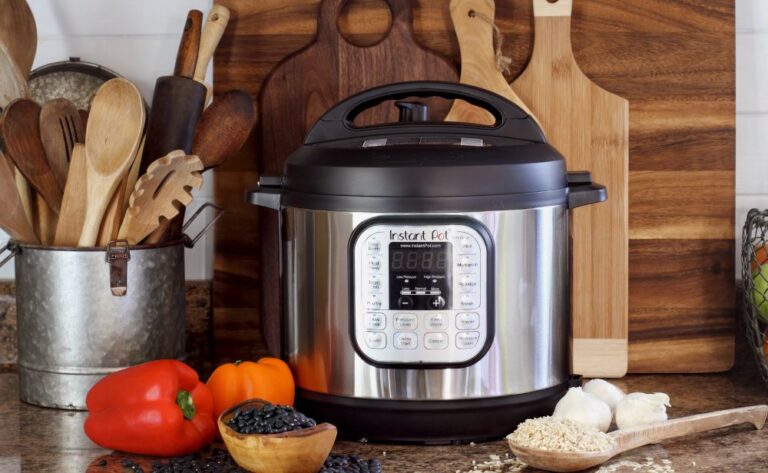 Instant Pot on kitchen counter with peppers, beans, rice, and garlic
