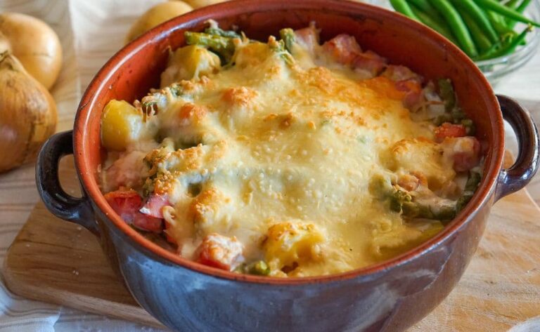 A cheesy casserole in a stoneware dish