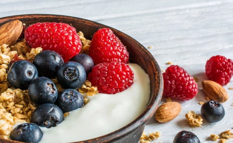 a bowl of homemade granola served with yogurt and berries